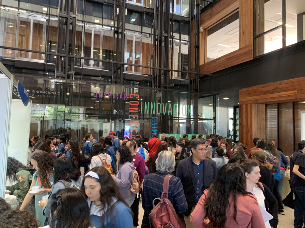 Fotografía donde aparece el salón central del Centro de Innovación de la Universidad Católica. Aparecen decenas de personas recorriendo la feria de tecnologías inclusivas, CEDETi 3 DE. 