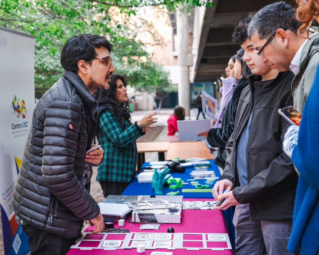 imagen en la que aparece desde lado algunas personas presentando en unos stand, mientras otras personas los visitas
