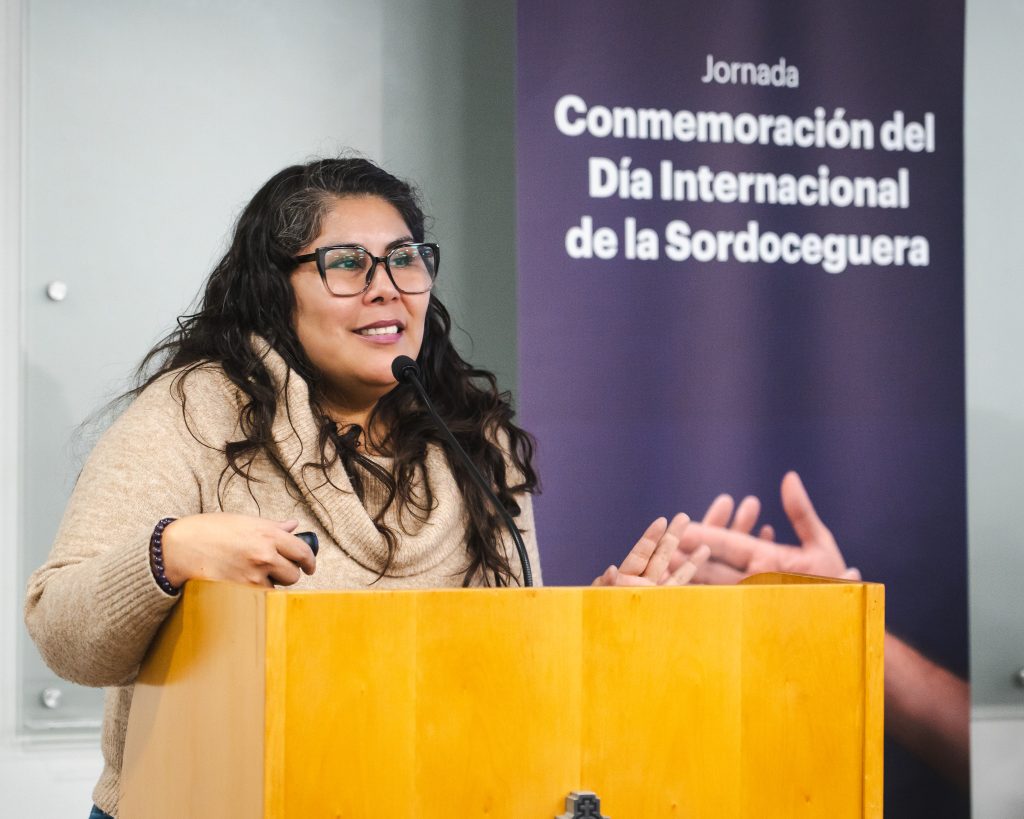 imagen en la que aparece Polín Olguín hablando en un podio. 