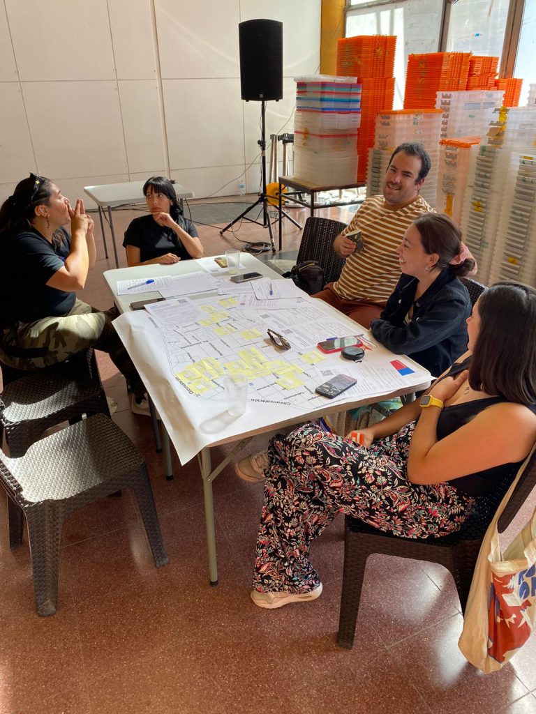 Fotografía en donde hay un grupo de personas sentadas en una mesa. 